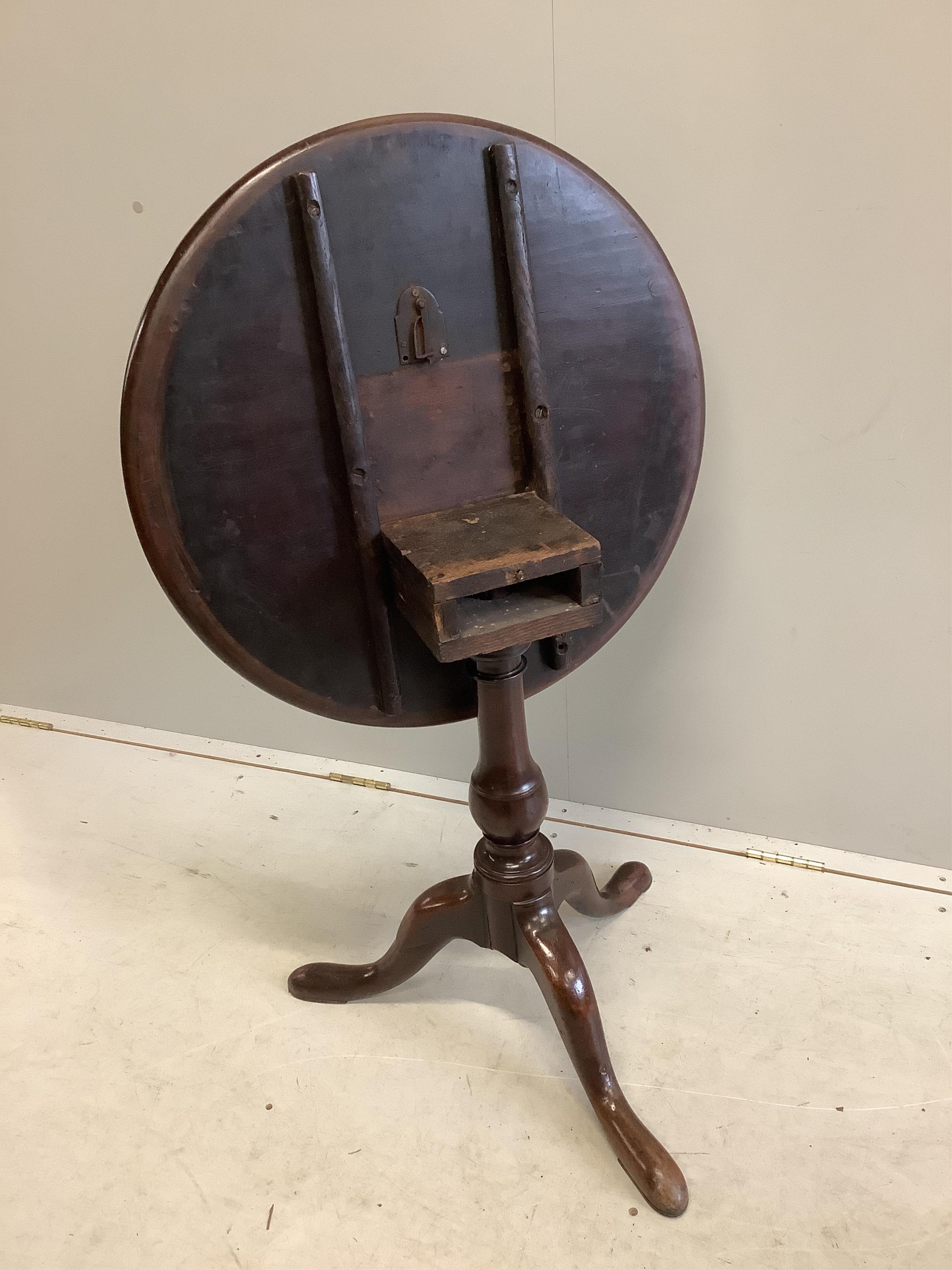 A George III circular mahogany tilt top tripod tea table, diameter 63cm, height 69cm. Condition - fair